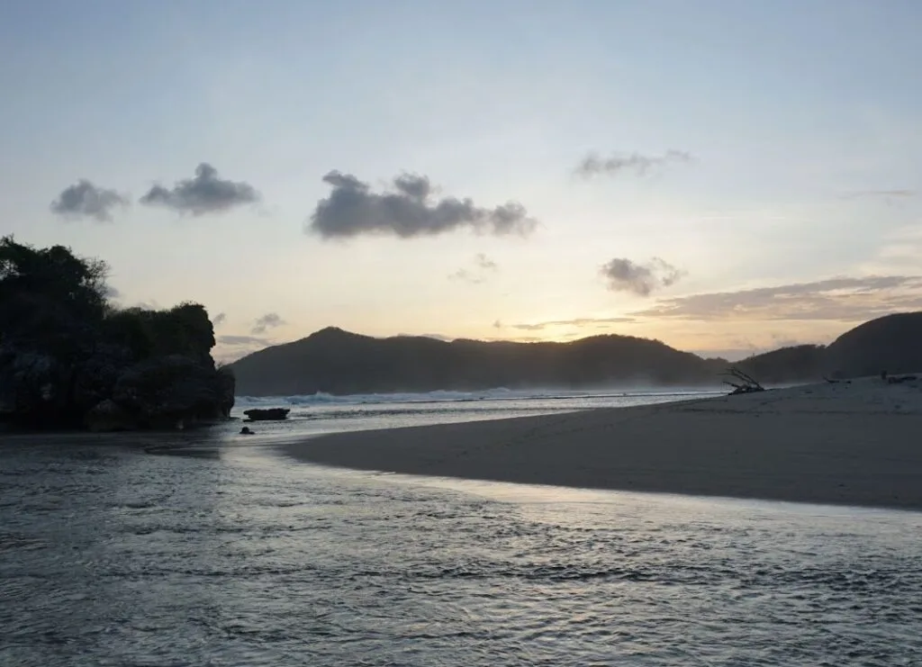 Quiet beach and rocky shoreline at sunset
